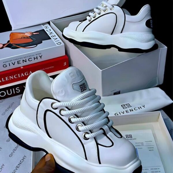 Sneakers in a white box with the GIVENCHY logo, alongside a book and a receipt.