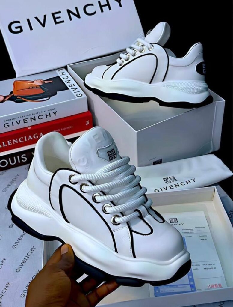 Sneakers in a white box with the GIVENCHY logo, alongside a book and a receipt.